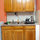Small kitchen, sink, dishes, electric stove. 
