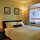 Master bedroom with queen bed, artwork and ample lighting
