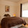 Queen sized bed in a quiet bedroom with sunlight and garden view. 