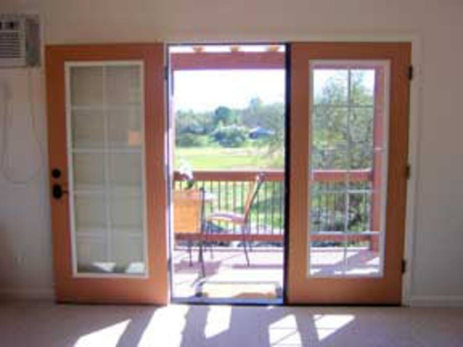 Inside the studio, looking out thru the balcony at meadows (green in Spring, golden in the summer).