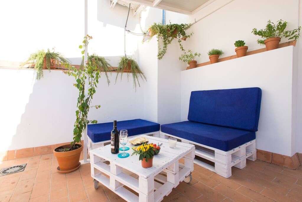 Terraza chill out con sofás de pallets contornado de plantas aromáticas (romero, albahaca, hierba luisa, menta, tomillo…),