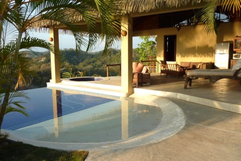 pool with beach entrance next to the tropical house