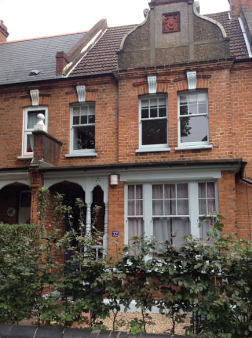 A beautiful old Arts & Crafts building with seating in the front garden - a nice spot to enjoy your morning coffee!